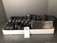 Photo of 23 assorted carved wooden stands arranged in a cardboard tray showing various shapes and sizes.