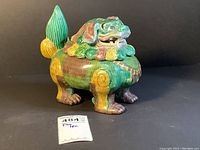 Front and right side view of the hand painted Chinese ceramic foo dog or guardian lion box showing detailed sculptural and painted features.