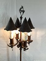 Full view of lamp showing overall height, four metal cone shades and deer finial