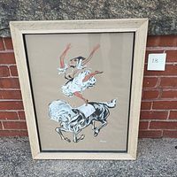 Frontal view of entire painting in natural wood frame leaning against brick and stone