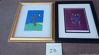 Two framed silkscreen artworks with Southwestern themes on a brown surface with lot number card