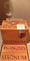 Clear burgundy wine glass on top of a wooden Magnum box labeled Royal Leerdam Holland, showing original packaging.