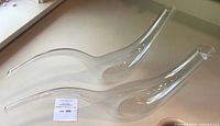 Pair of clear, elongated Riedel crystal wine decanters side by side, showing modern curved shape and wide bases