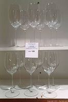 Twelve glasses arranged on shelves, six upper and six lower