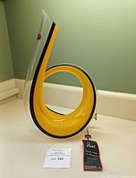 Full view of horn‐shaped decanter standing upright on counter with tag and lot card visible