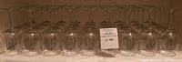 Photo showing 36 clear wine glasses arranged upside down in rows, highlighting their uniform size and shape.