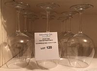 Multiple glasses stored upside down on a shelf.