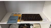 Wooden Chinese abacus, two instructional booklets, and an instruction sheet on a white shelf.