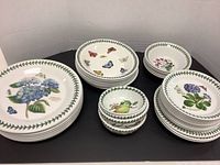 Overview of stacked dinner plates, bowls and side plates in Botanic Garden pattern