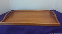 Top and side angled view showing full tray surface, handles, and wood grain detail.