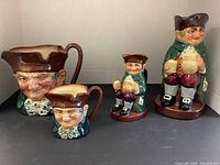 Photo showing all four Royal Doulton Toby mugs depicting Old Charlie, with two larger and two smaller mugs together.