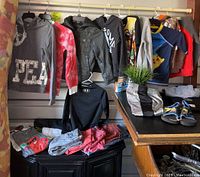 Full overview of hanging and folded boys clothes including jackets, pants, shoes, and shirts in various colors and brands.