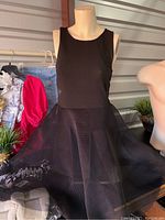 Black sleeveless junior fitted dress with mesh skirt on mannequin