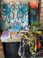 Photo of octopus design curtains with assorted linens and pillows arranged on a black cabinet