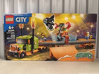 Front view of the sealed LEGO City Stunt Show Truck 60294 box showing the stunt truck, ramp, motorcycle, and minifigures in an action stunt show scene.