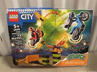Lego City Stunt Competition 60299 box showing the set's contents and theme with two motorcycle minifigures and stunt accessories including a fire loop and ramp.