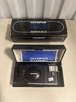 Top view of Olympus XA2 box with camera, flash and manual inside