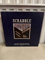 Front of the navy blue box labeled 'Scrabble Deluxe Vintage Edition' with a photo of the game board and tiles