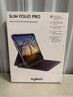 Product packaging for Logitech Slim Folio Pro keyboard case indicating compatibility with iPad Pro 11-inch 1st and 2nd generation, key features include Bluetooth low energy technology, adjustable backlit keys, iOS shortcut keys, rechargeable battery, and Apple Pencil support.