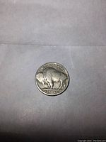 Reverse side of 1935 Buffalo Nickel showing American buffalo with inscriptions 'UNITED STATES OF AMERICA' and 'FIVE CENTS'.