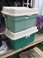 Pair of large Rubbermaid storage totes stacked, showing lids and colors