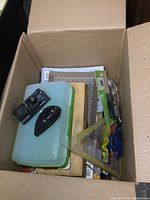 Box open showing a variety of modelling tools, small containers, and accessories inside