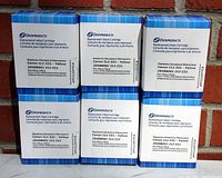 Photo showing six sealed boxes of Dataproducts Canon CLI-221 yellow inkjet cartridges stacked in two rows against a brick wall background.