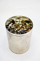 Image of a large metal can filled with various vintage metal drawer handles and hardware pieces.