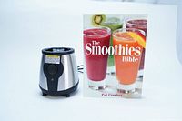 Photo of the GNC On-the-Go Blender bottom part and the book titled 'The Smoothies Bible' showing smoothie recipes by Pat Crocker.