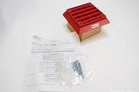 Red Eaton Wheelock vandal-resistant speaker with mounting screws and documentation laid out on white surface