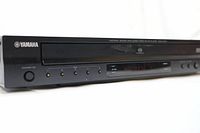 Front view showing Yamaha brand logo, disc tray, and playback indicators on the DVD player.