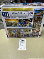 Box of 10 Photo Gallery premium puzzles showing front details including images of puzzle themes and piece counts ranging from 300 to 1000 pieces