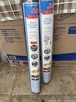 Shows two rolls of Jobe Premium Weed Control Fabric standing with packaging visible, including size and main features.