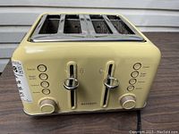 Front view of cream-colored Buydeem 4-slice toaster showing dual control levers and function buttons