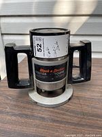 Photo of Black & Decker router placed on wooden surface showing entire body, handles, and labeling details.