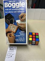Deluxe Boggle game box and 3x3 Rubik's Cube displayed side-by-side on table.