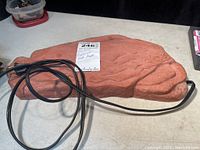 Full view of the Zoo Med Repticarre Rock Heater including power cord on a flat surface.