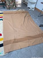 Unfolded blanket laid flat on floor showing overall color, size and condition