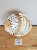 Front view of oval ceramic footed bowl with abstract mid-century pattern in brown, cream, and black tones