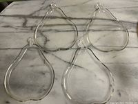 Top-down view of four clear glass plates arranged in a group on a marble-like surface.