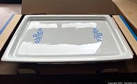 Corning Ware broil bake tray with blue floral pattern displayed in original cardboard cradle.