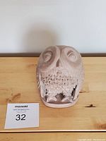 Frontal view of vintage owl statuette on wooden surface with auction lot card.