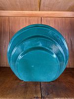 Front view of the teal green ceramic vase showing concentric circular design and glossy finish.