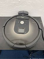 Top view of the iRobot Roomba vacuum with the Clean button and transparent cover showing internal components.