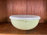 Large yellow plastic bowl with translucent white lid shown from side.