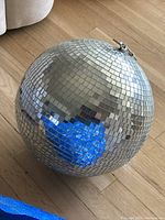Full view of the disco ball showing its overall appearance and size on wooden floor.
