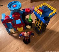 View of the flying Superman figure with string, and two playsets: Daily Planet and a Batman tower piece