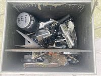 Inside of black heavy-duty plastic box showing multiple grip and film production clamps and accessories tightly packed inside.