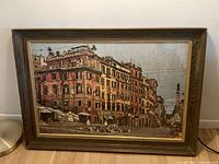 Full view of framed painting showing Italian street scene with buildings and plaza.