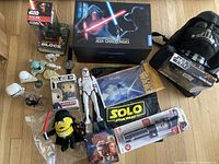 Photo showing the full collection including Lenovo Jedi Challenges box, lightsaber, various Star Wars figures, Funko Pop figure, plush toys, posters, and branded bags.